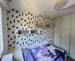 Papel pintado infantil con gatos negros en habitación infantil en San Sebastián, instalación profesional por Jusa Pintores.