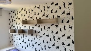 Papel pintado infantil con gatos negros en habitación infantil en San Sebastián, instalación profesional por Jusa Pintores.