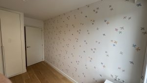 Papel pintado infantil con aves multicolor en habitación luminosa