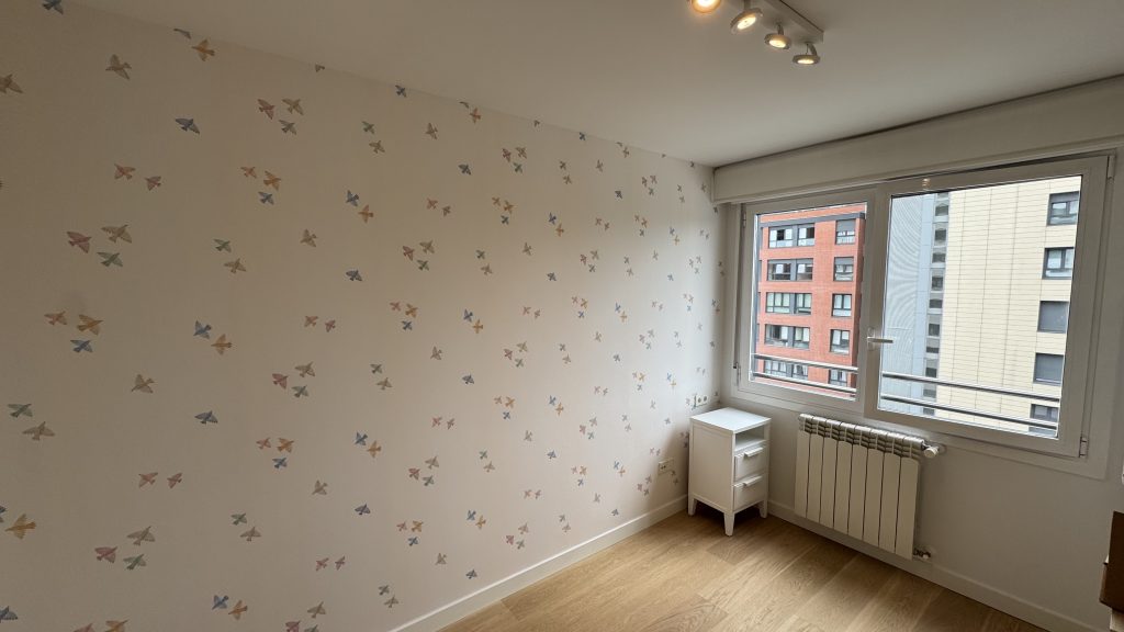 Papel pintado infantil con aves multicolor en habitación luminosa