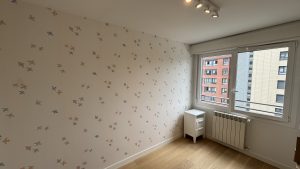 Papel pintado infantil con aves multicolor en habitación luminosa