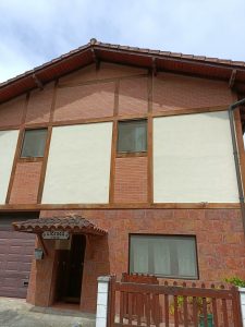 Detalle de fachada con madera exterior barnizada y ladrillo impermeabilizado